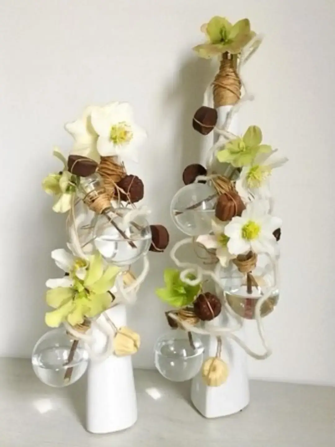 Présentation de truffes au chocolat et fleurs d'hélébores sur soliflores blancs contemporains par Cindy Gunther