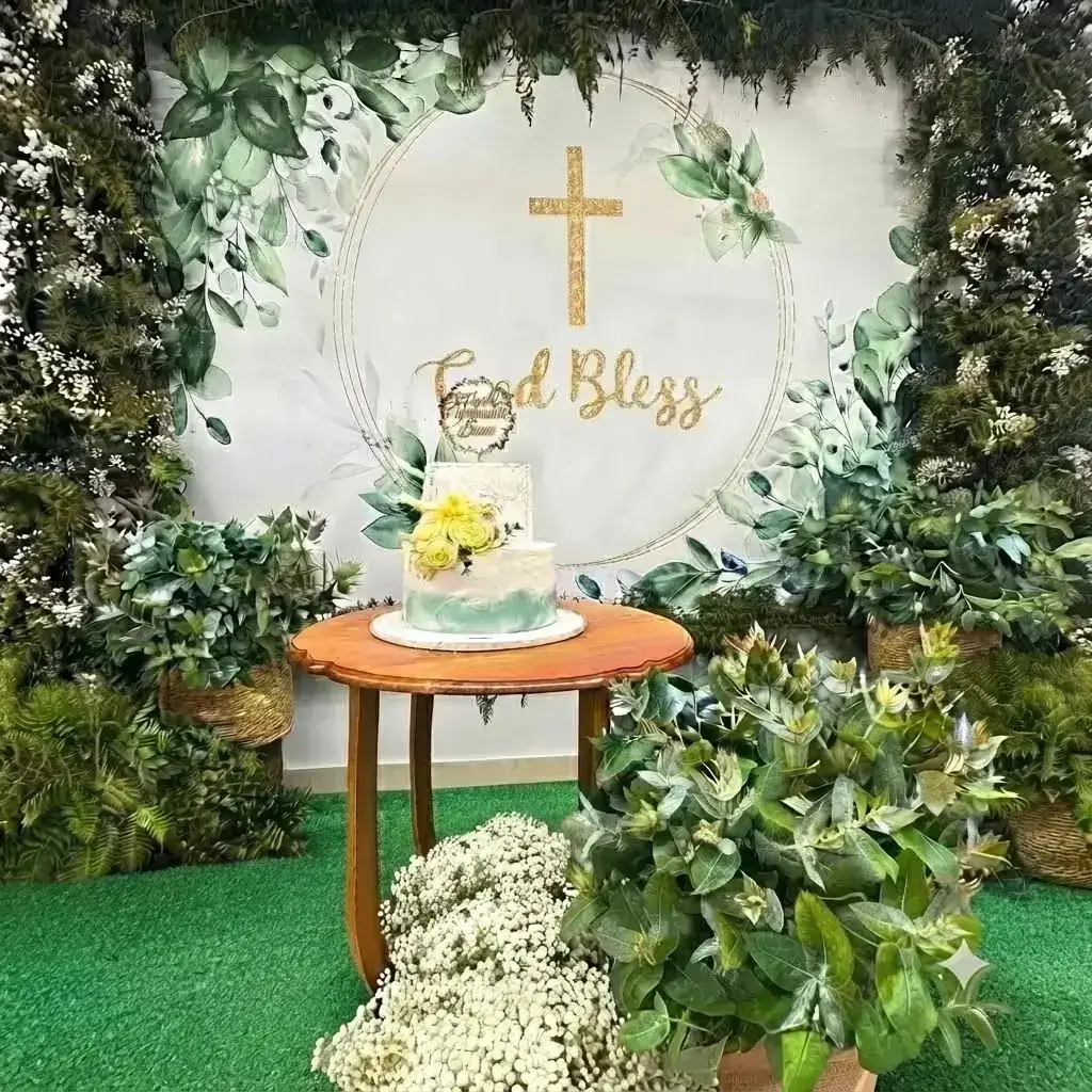 Mur de feuillages et gypsophile avec fond photo pour un décor de communion au Portugal par Cindy Gunther avec gâteau assorti blanc et vert d'eau.
