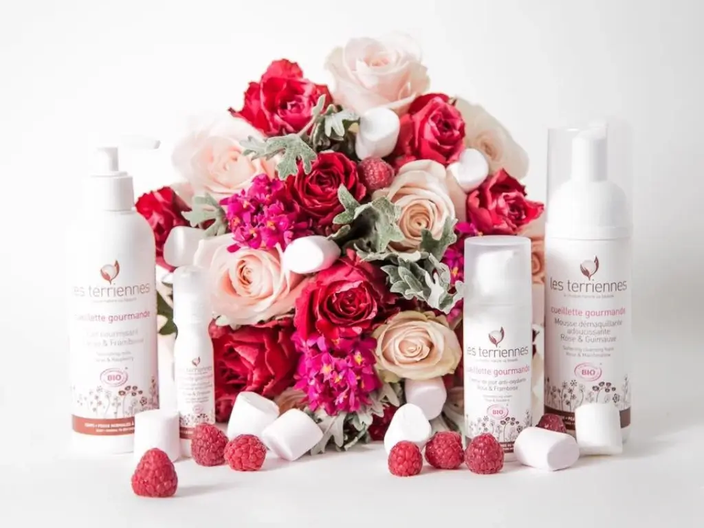 Composition florale épurée avec roses, framboises et guimauves encadrant des produits cosmétiques bio, Cindy Gunther
