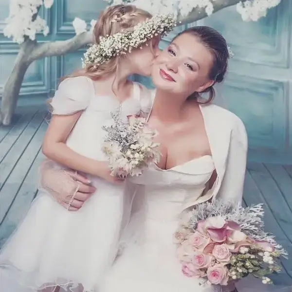 Mariée avec son bouquet poudré et demoiselle d'honneur couronnée de gypsophile partageant un moment de complicité. - Cindy Gunther