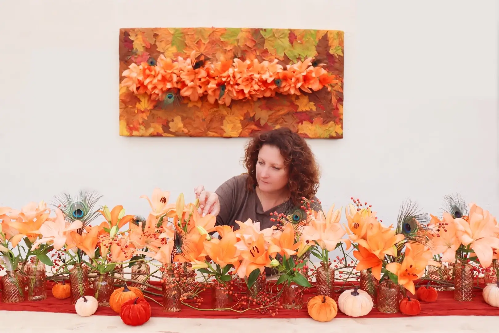 Vue de l'artiste Cindy Gunther façonnant des fleurs au sein d'une composition d'art floral sur table.