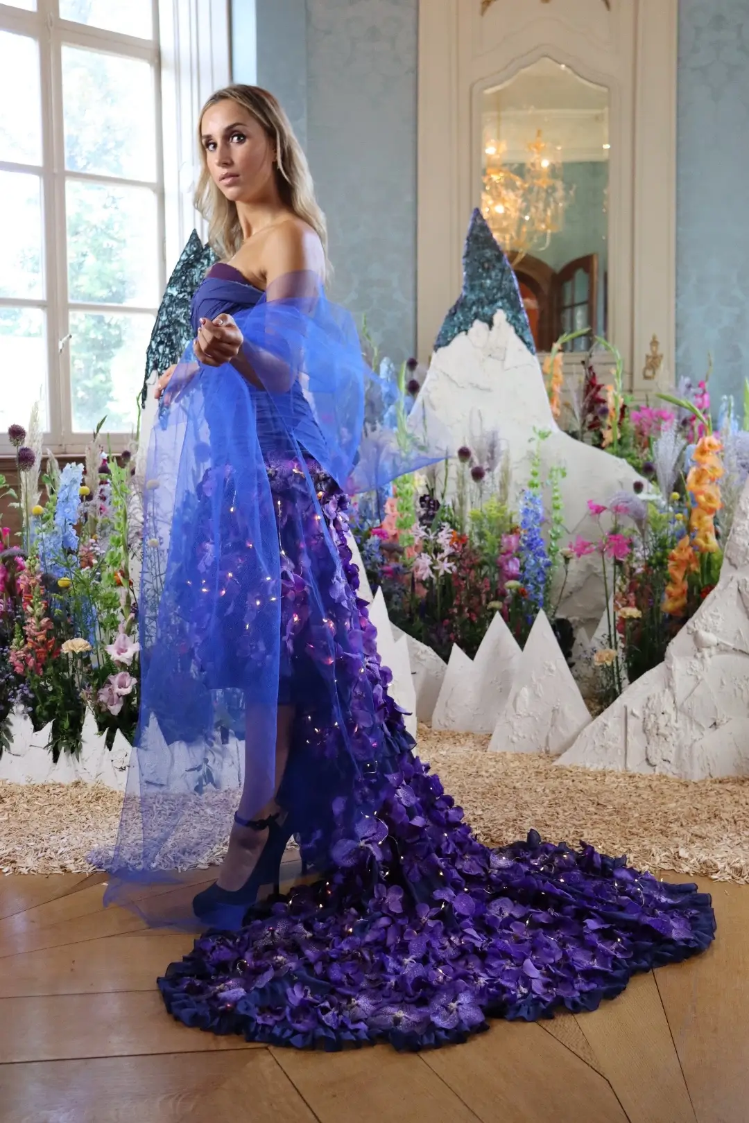 Robe de soirée couleur nuit ornée de 500 orchidées Vanda et de micro-LEDs, réalisée par Cindy Gunther et présentée lors d'un défilé en Belgique.