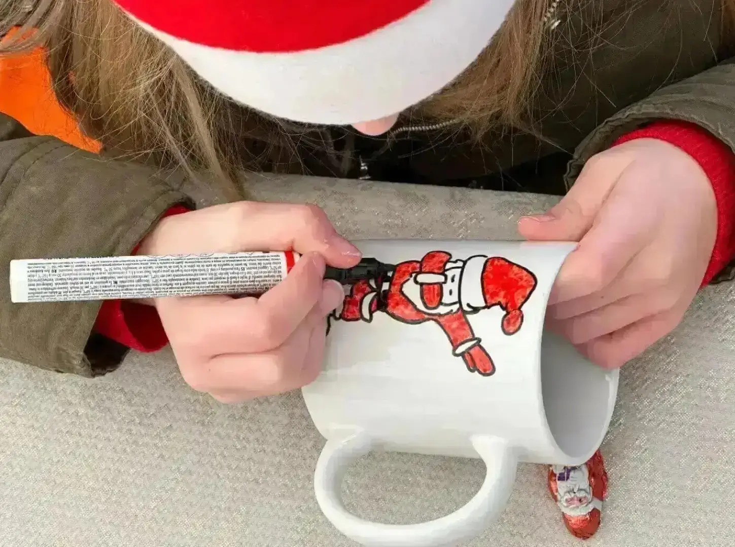 Enfant peignant un mug de Noël lors d'un atelier créatif animé par Cindy Gunther